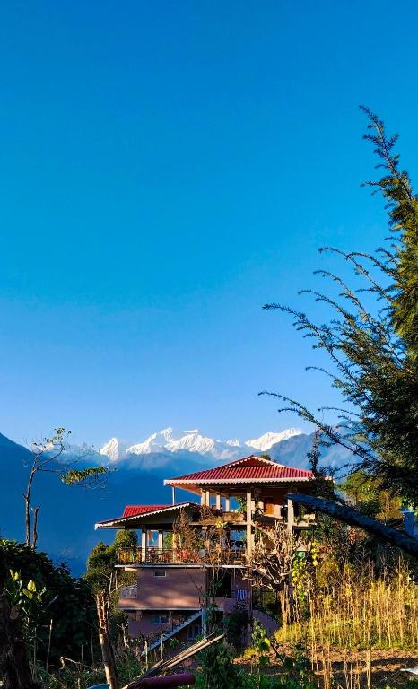 una casa su una collina con montagne sullo sfondo di Mandavya homestay a Pelling