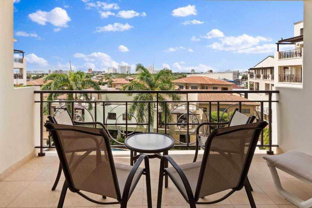 パーム・イーグル・ビーチにあるPC406 - Pool View - 1 BR Perfect for a couple - Close to Palm Beach - 1BRの椅子とテーブルが置かれたバルコニー