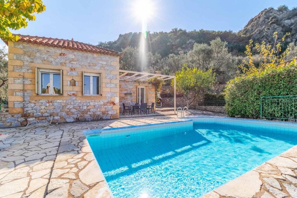 a villa with a swimming pool in front of a house at Villa Palataki III in Kardamyli