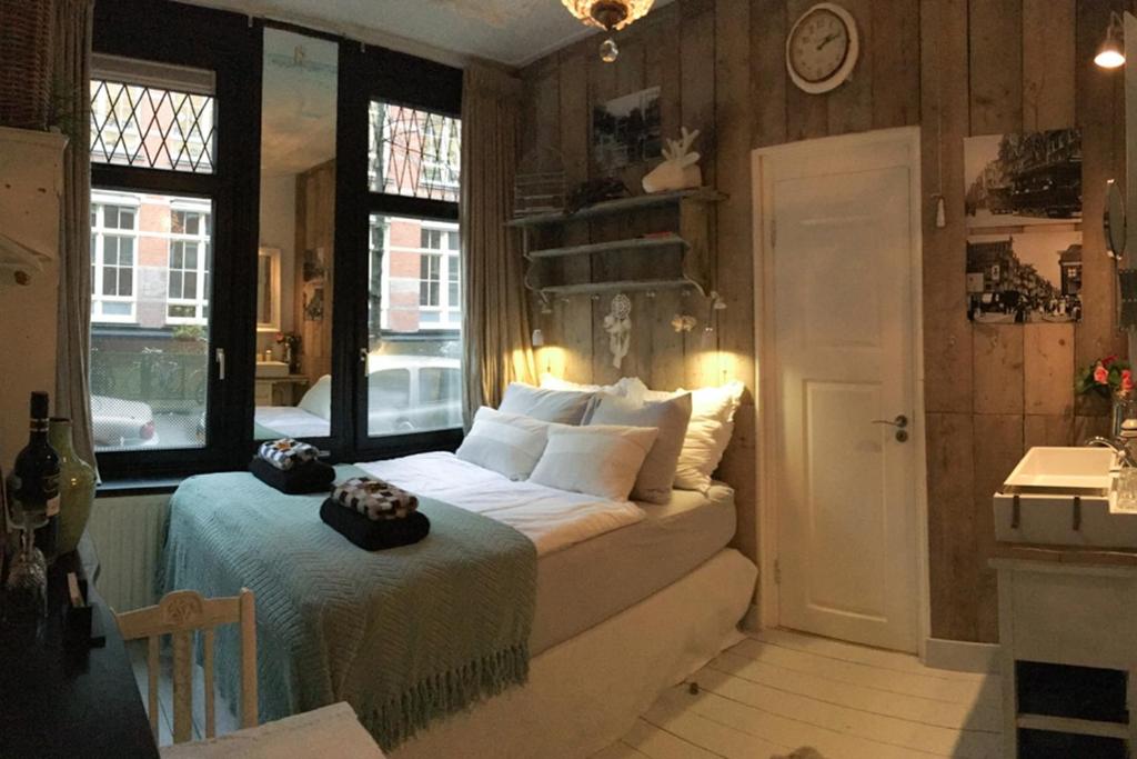 a bedroom with a bed and a window at Guesthouseamsterdam in Amsterdam