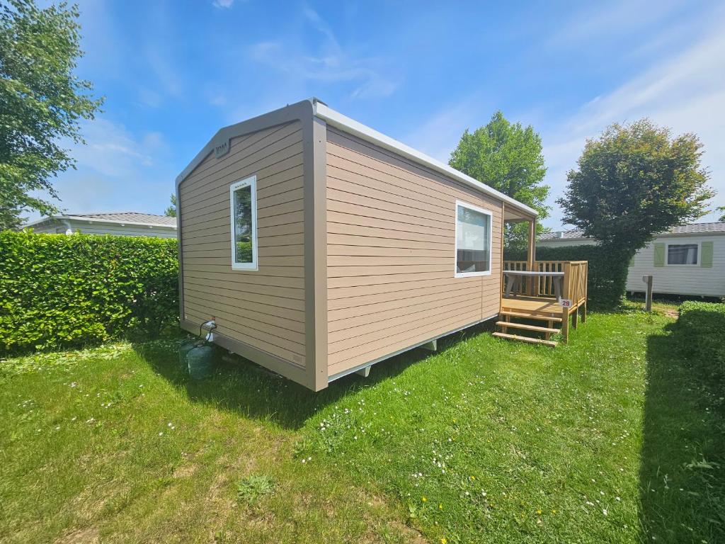 a tiny house with a deck in a yard at loggia 29 in Biville-sur-Mer