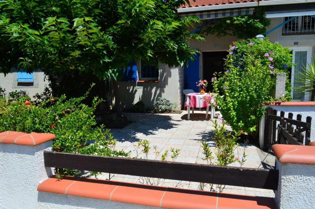 un jardin avec un banc devant une maison dans l'établissement Maison 2 pièces mezzanine 5 couchages ARGELES SUR MER AR150-066, à Argelès-sur-Mer