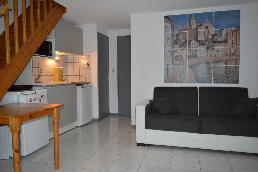 a living room with a couch and a kitchen at Maison 4 pièces ARGELES SUR MER AR300-027 in Argelès-sur-Mer
