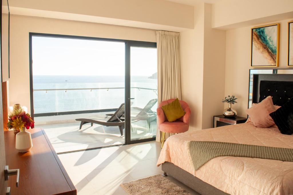 a bedroom with a bed and a view of the ocean at Malecón Love in Mazatlán