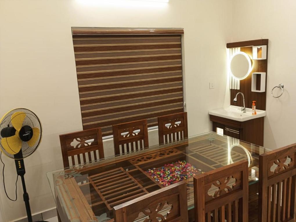 a room with a glass table and a fan at Heaven meadows Homestay in Vagamon