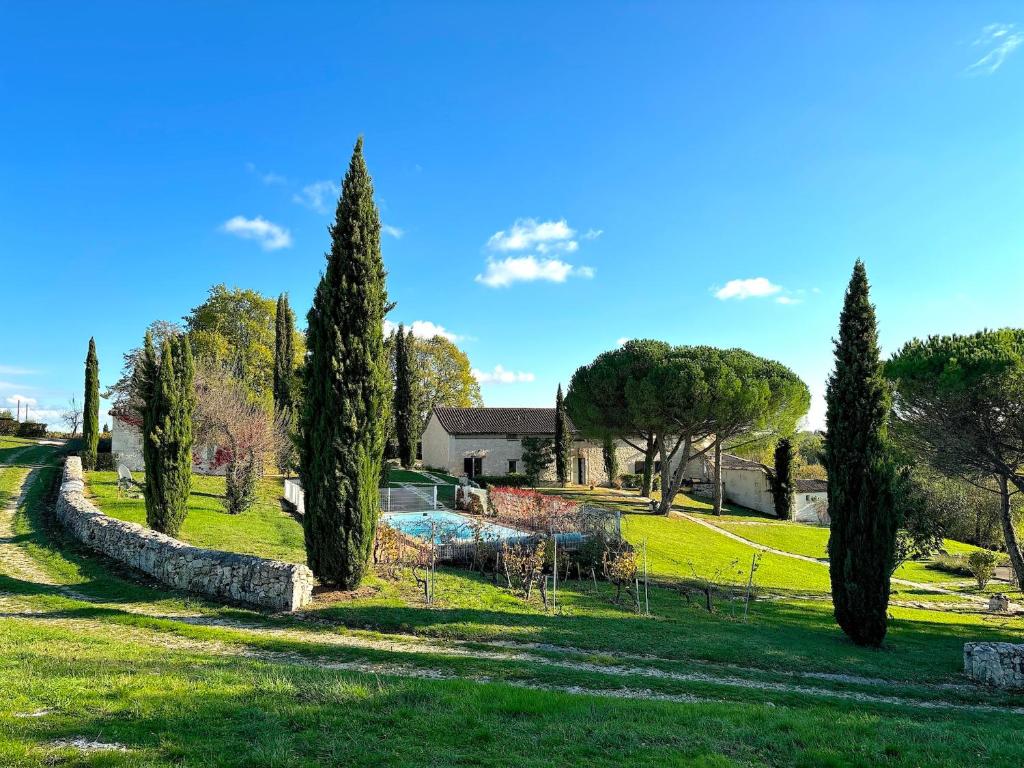 a park with a pond and trees and a house at Cottage Coeur des Vignes in Fargues