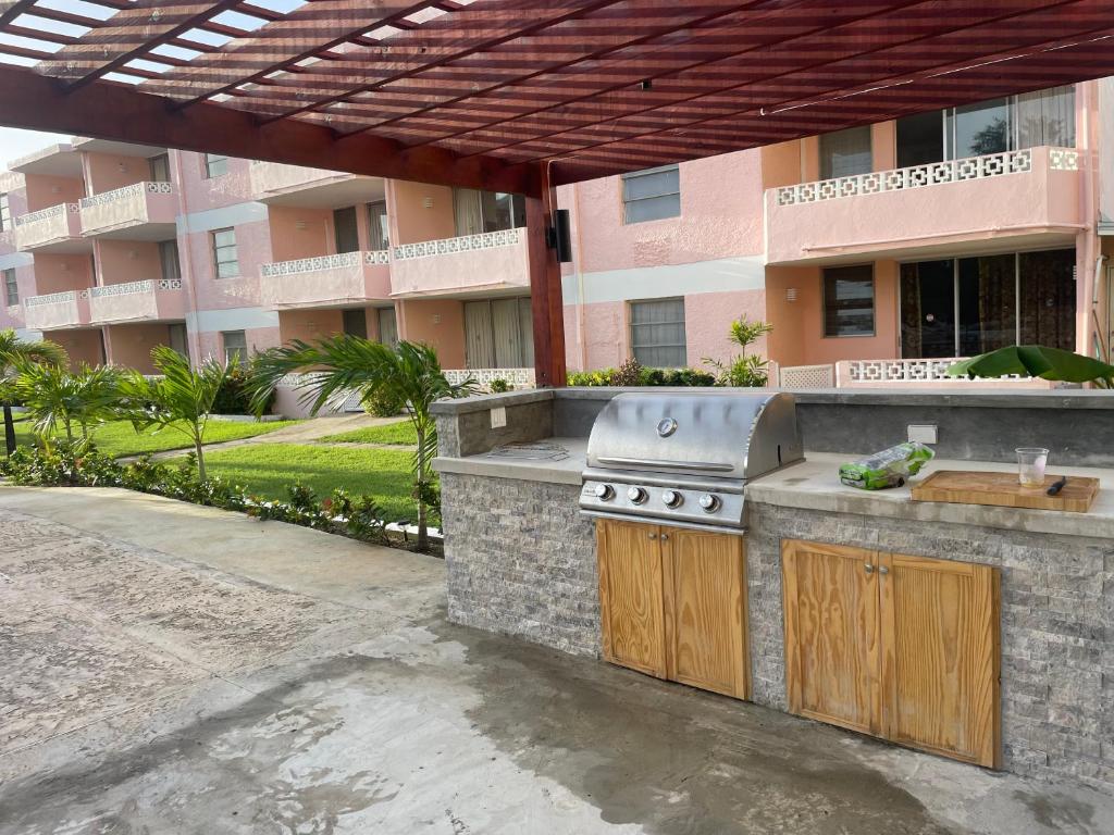 a outdoor kitchen with a grill in front of a building at The Monteray Hotel in Christ Church