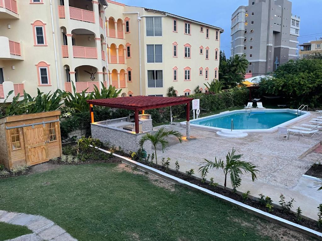 a backyard with a swimming pool and a gazebo at The Monteray Hotel in Christ Church