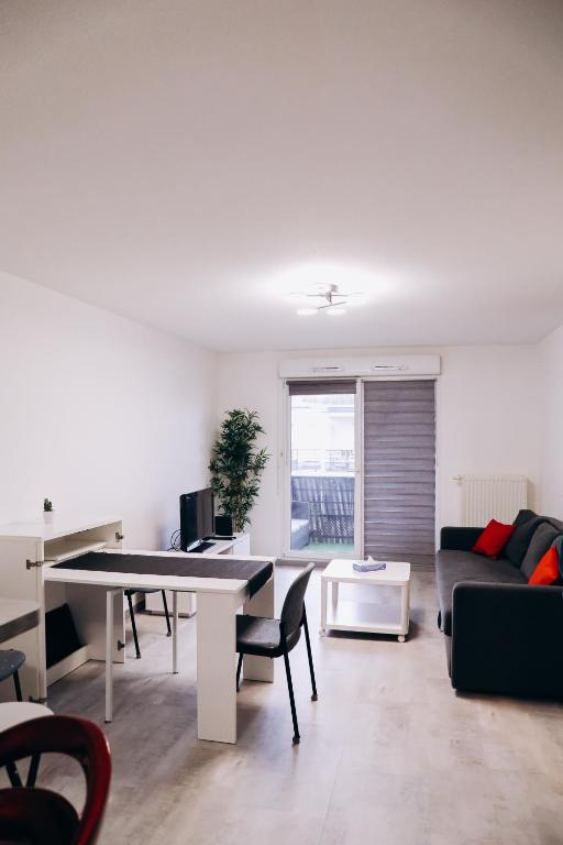 un salon avec une table et un canapé dans l'établissement Appartement , Strasbourg France, à Strasbourg