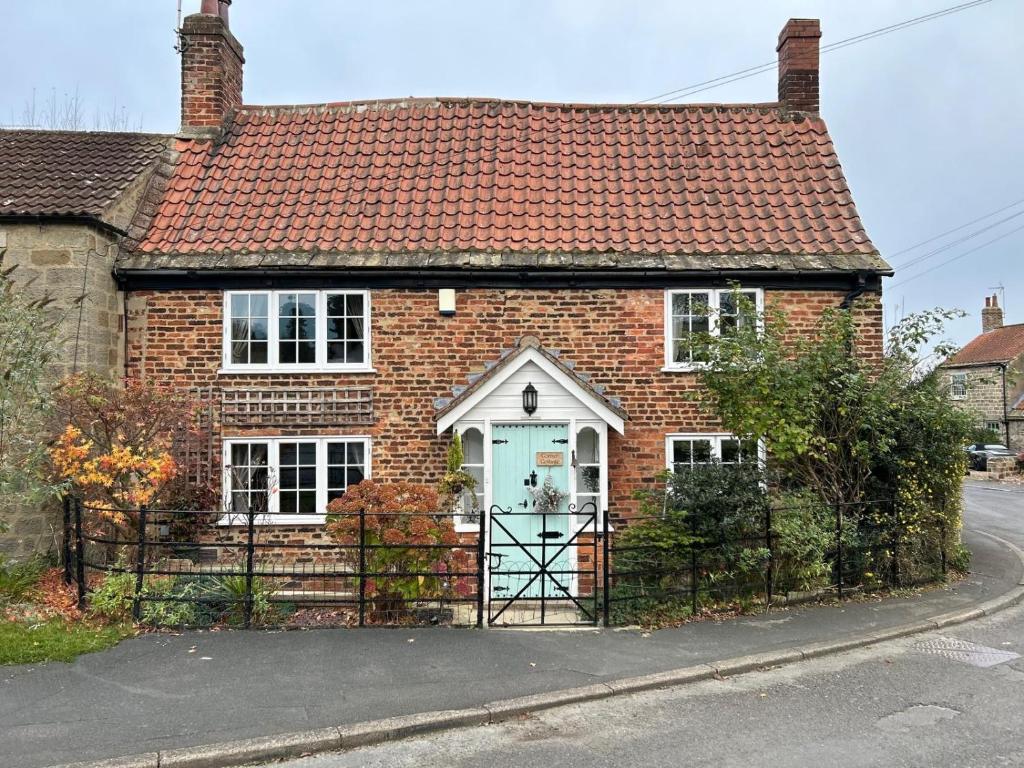 a brick house with a gate in front of it at Corner Cottage in Knaresborough