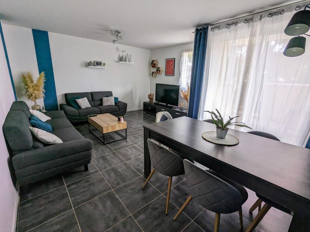 - un salon avec un canapé et une table à manger dans l'établissement Appartement idéal circuit des 24h du Mans, au Mans