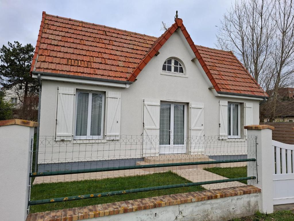 une maison blanche avec un toit rouge dans l'établissement Les MOUSSES, à Varaville