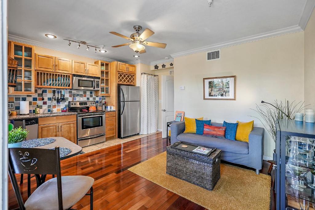 a living room with a blue couch and a kitchen at Wine-Dine-Sunshine Cozy Flat in The Heart of DTSP in St Petersburg