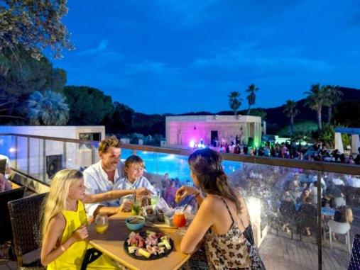 grupa ludzi siedzących przy stole na balkonie w obiekcie MOBIL HOME DÉTENTE 8 personnes w mieście Le Muy