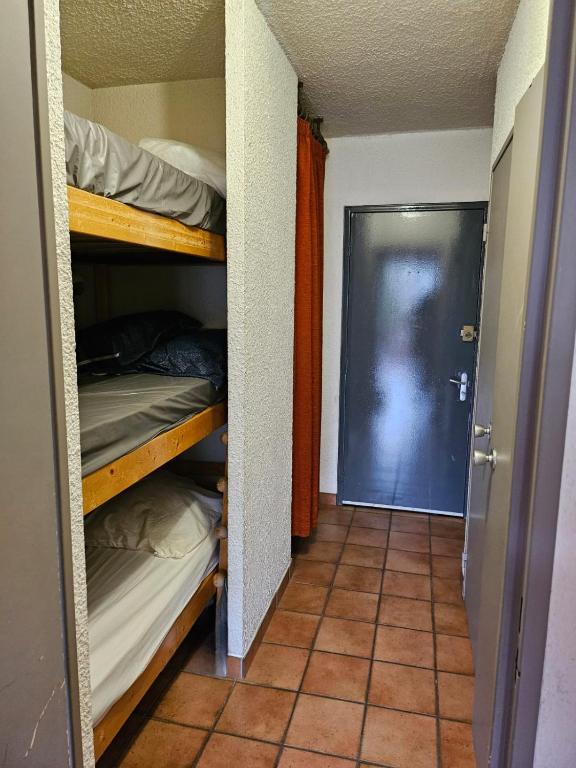 - un couloir avec des lits superposés dans une chambre avec une porte dans l'établissement le Meollion, à Orcières