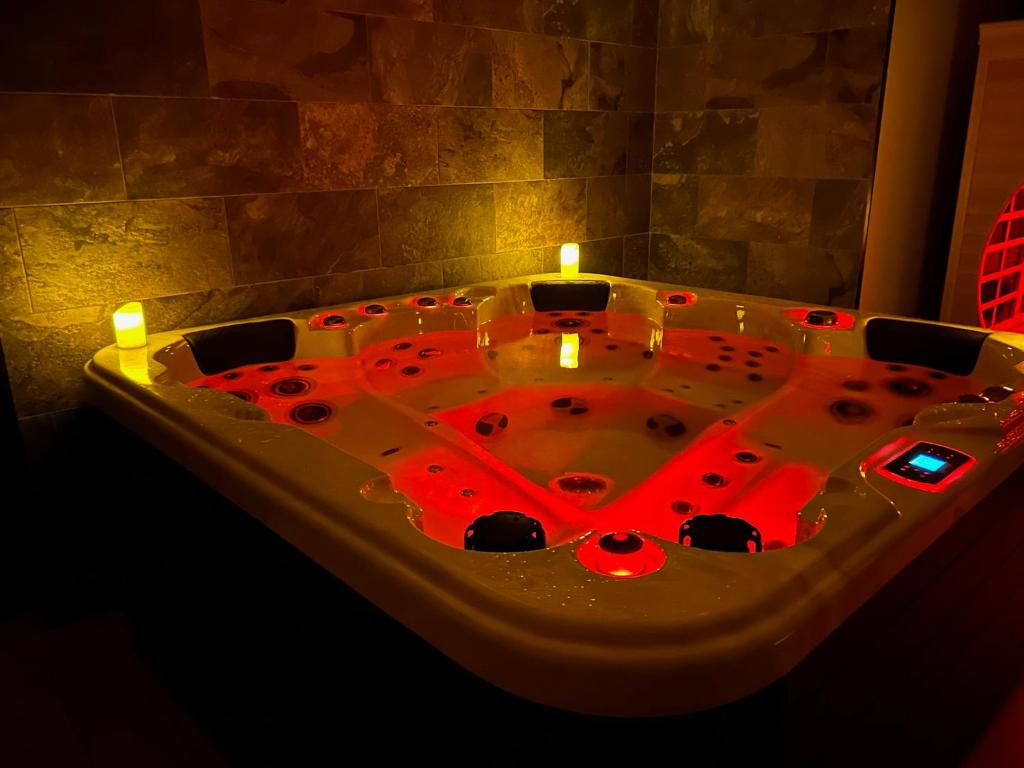 una vasca da bagno con luci rosse in camera di Art des sens - SPA et Sauna privatifs a Boulogne-sur-Mer