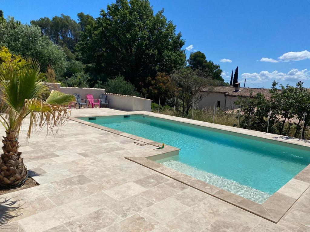 une piscine dans une cour arrière avec un palmier dans l'établissement La Bastide des Amis, à Flayosc