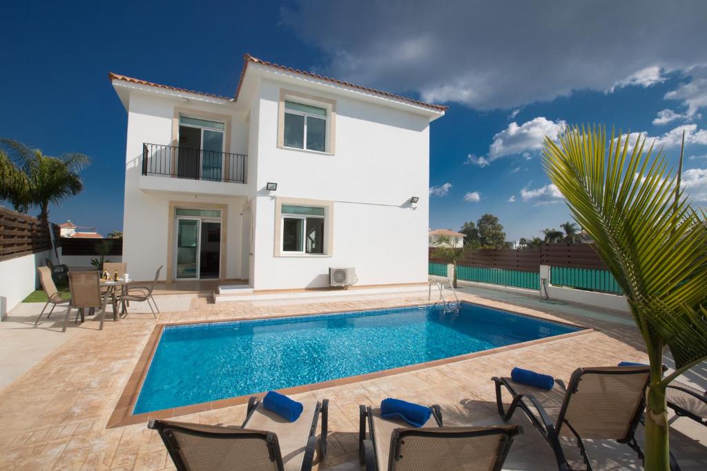 a villa with a swimming pool in front of a house at Halle Villa in Protaras