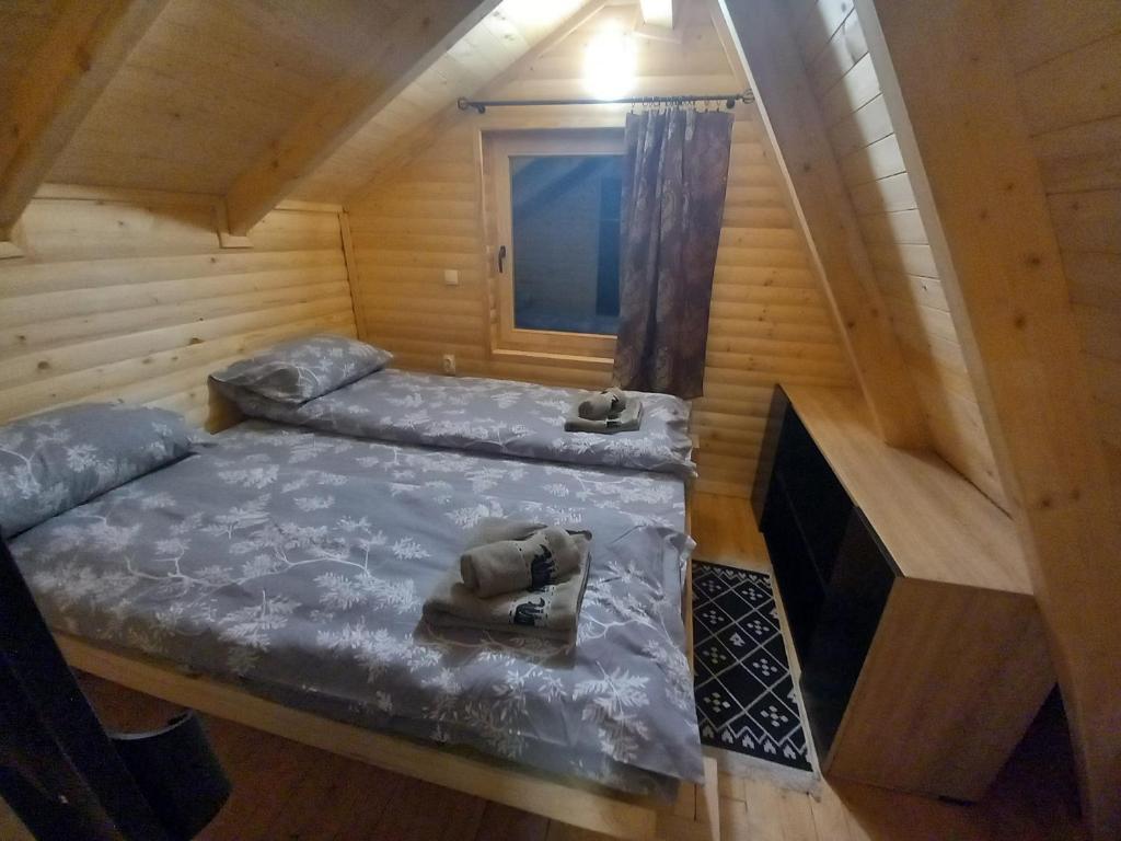 a bedroom with two beds in a wooden cabin at Planinska Vikendica SP Jahorina in Bistrica