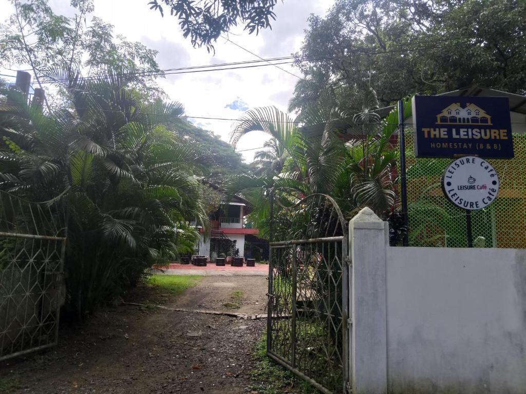 a gate in front of a house with a sign at The Leisure Home Stay in Shādipur