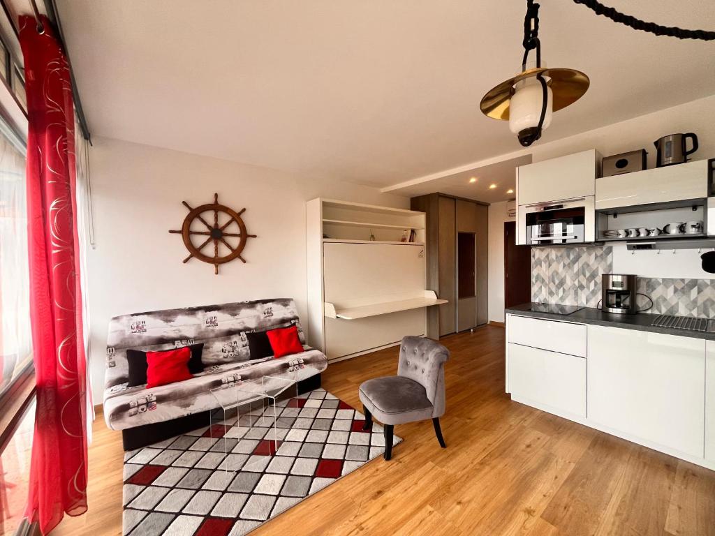 Heliotel Marine Studio avec balcon au 4eme étage à 200m de la mer في سان لوران دو فار: غرفة معيشة بها أريكة وطاولة