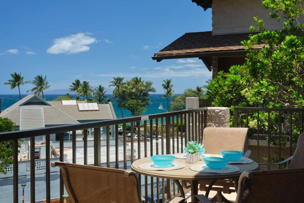 a table on a balcony with a view of the ocean at Stylish Maui Loft Split AC Ocean Views Lanai in Kihei
