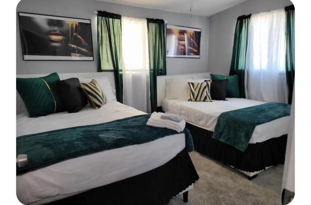 two beds in a room with green curtains at Pool home in Las Vegas