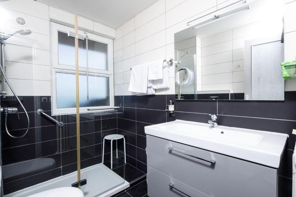 a bathroom with a sink and a toilet and a mirror at Saint Aubin Logis Hôtel & Restaurant in Saint-Aubin-sur-Mer