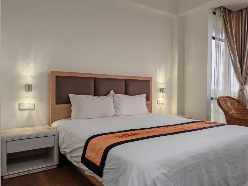 a bedroom with a large white bed with a window at Urban Oasis Apartment 5 in Melaka