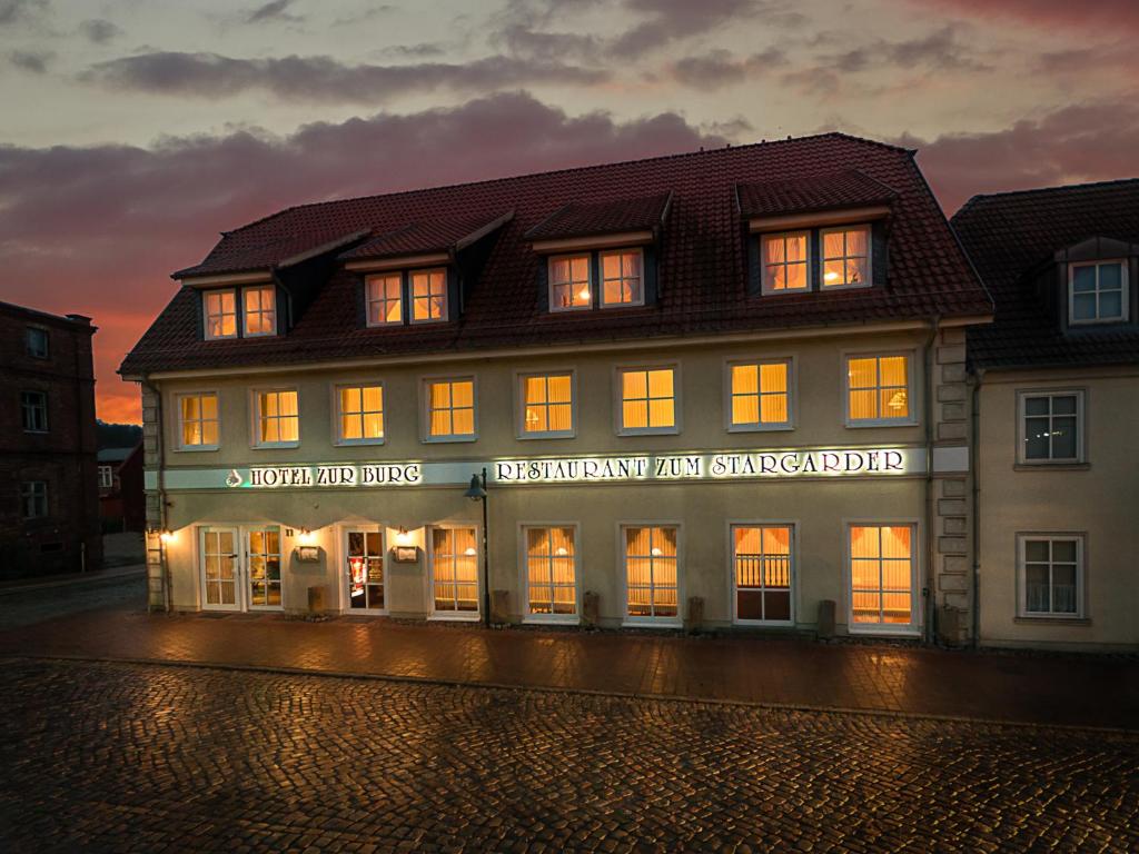 um edifício com uma placa na frente dele em Hotel Zur Burg GmbH em Burg Stargard