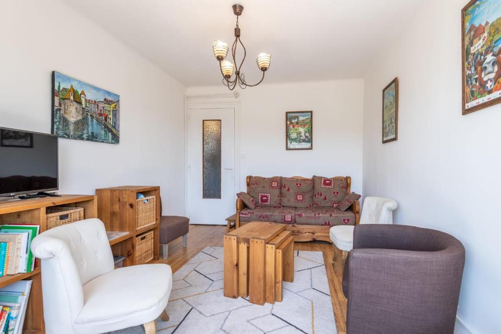 un salon avec un canapé, une table et des chaises dans l'établissement IMPERIAL - Appartement confortable près du lac, à Annecy