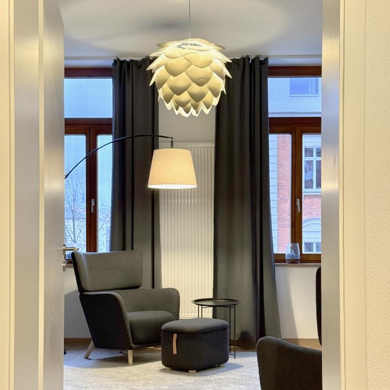 a living room with a chair and a chandelier at Feinzeit Lovely Lou - renovierter Altbau, Design, Zentrum! in Bamberg
