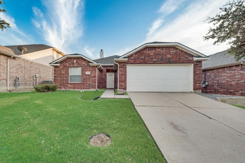 a brick house with a white garage at Luxury And Cozy Home 3BD, 2BATHS in Little Elm