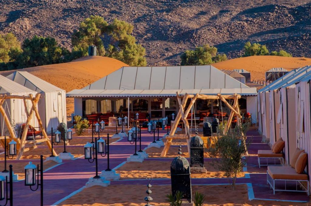 un edificio nel deserto con montagne sullo sfondo di Sahara Desert Camp a Merzouga