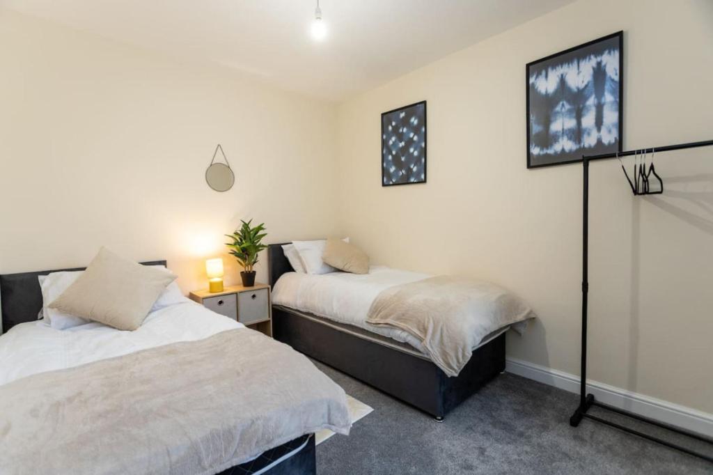 a bedroom with two beds and a tv on the wall at Deacon Street-3 Bedroom, Sleeps 7, Long Stay Disc, Parking in Swindon