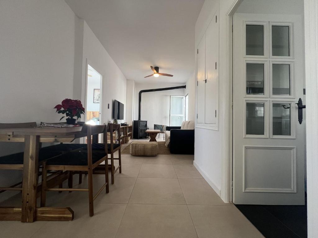 a dining room and living room with a table and chairs at El Mirador del Asno in El Bosque