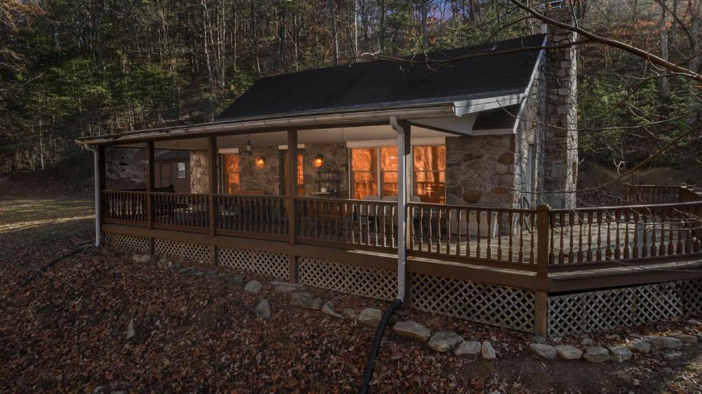 a cabin in the woods with a wrap around porch at River Access Loft Deck WiFI & Pet Friendly in Great Cacapon
