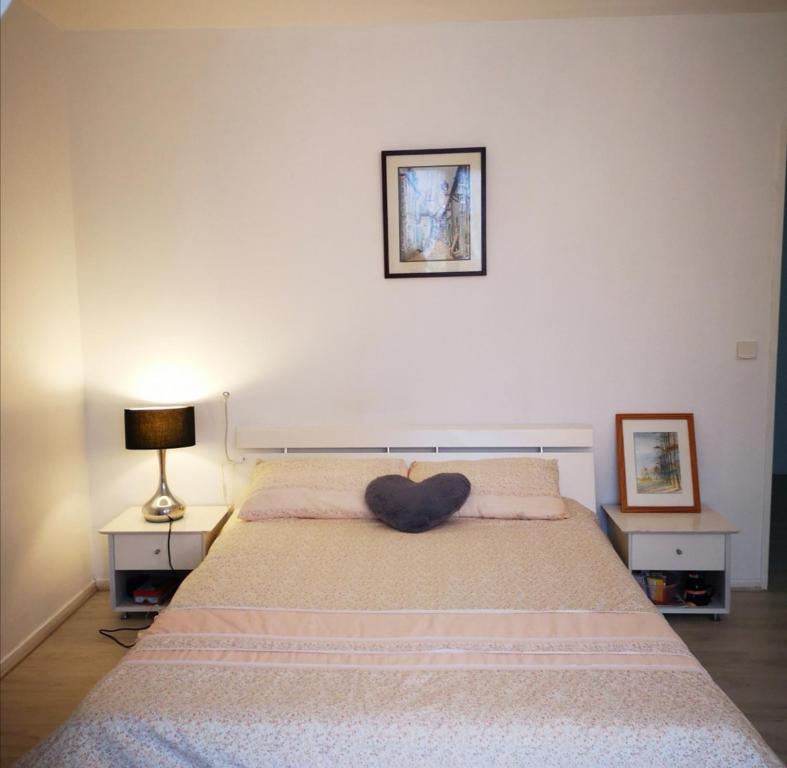 une chambre avec un lit avec un ours en peluche dessus dans l'établissement 玫瑰花苑, à Bussy-Saint-Georges