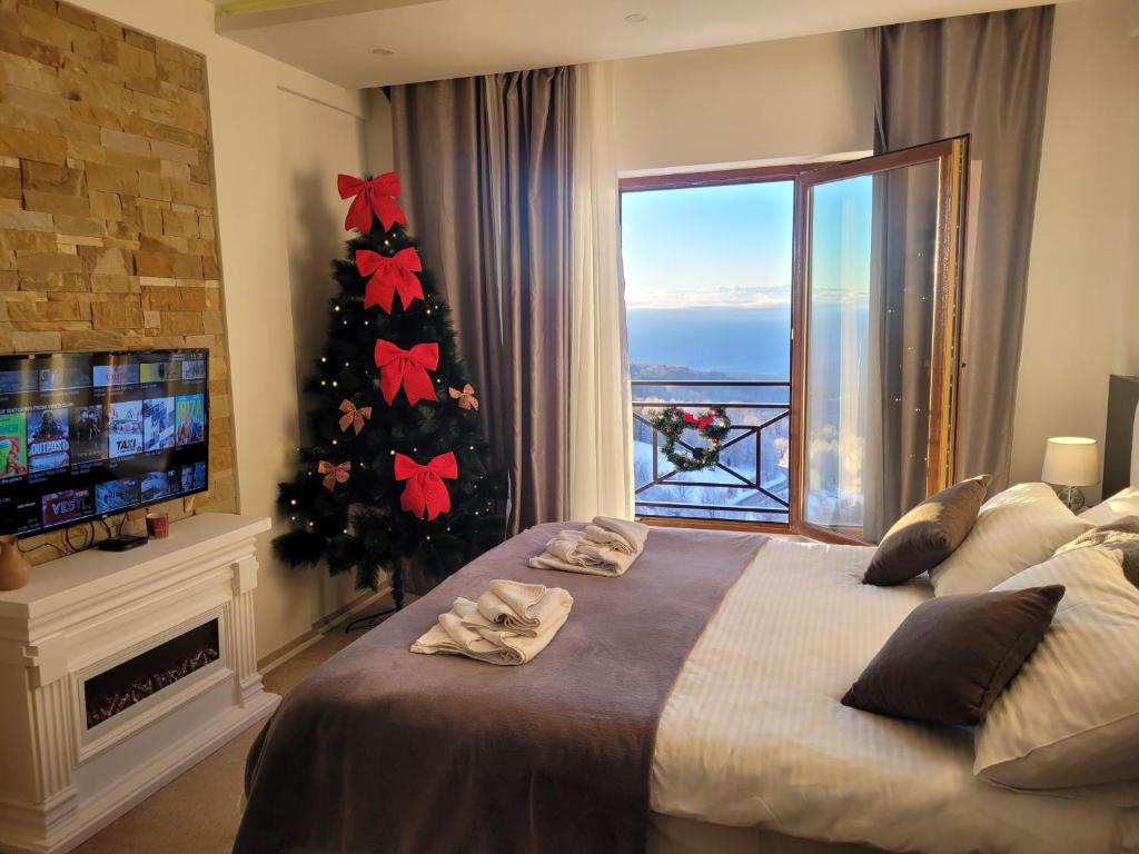 a bedroom with a christmas tree and a large bed at Milmari N66 in Kopaonik