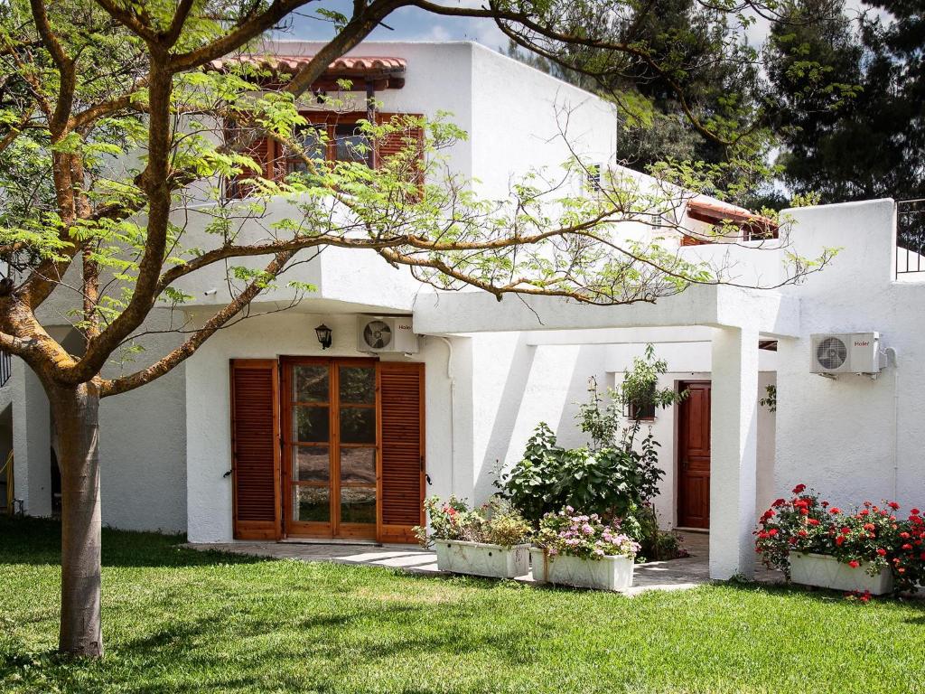 a white house with a tree in the yard at Eretria Park Studios in Eretria