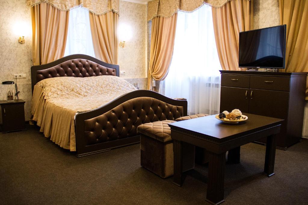 a bedroom with a bed and a table and a tv at VO Hotel in Moscow