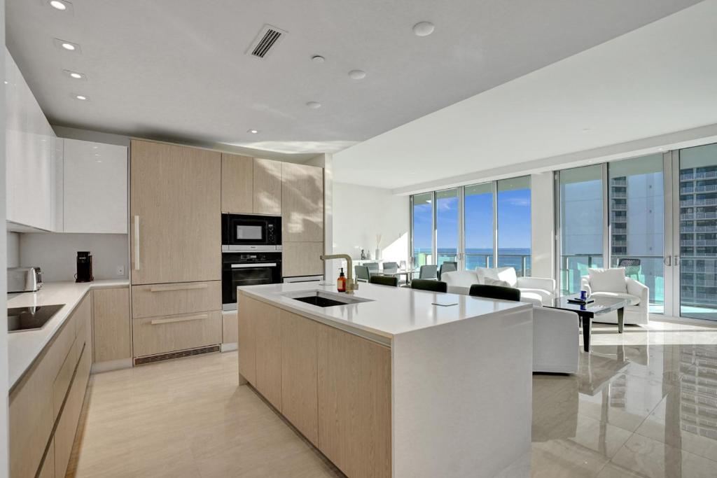 a kitchen with white counter tops and a living room at 2BR Ocean Views Condo in West Palm in Riviera Beach