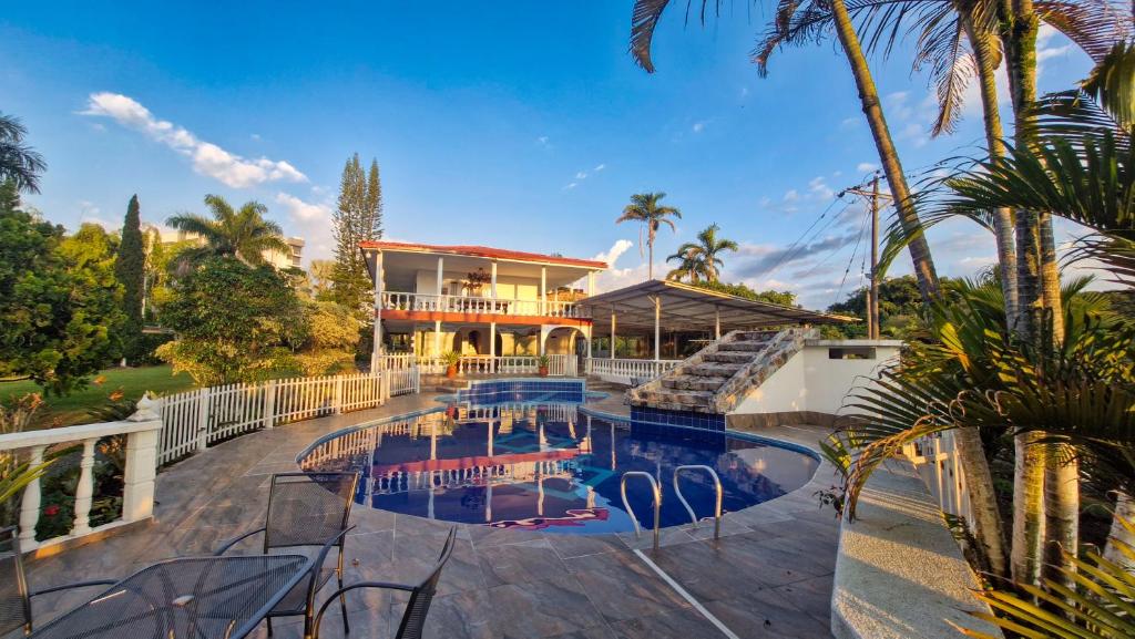 a house with a swimming pool in front of a house at Hotel Campestre Villa Esmeralda in Pereira