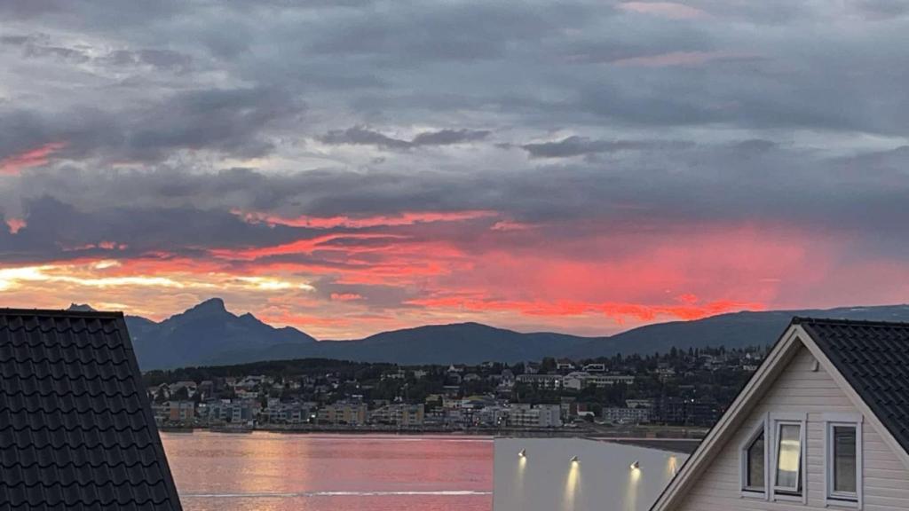 a sunset over a city and a body of water at Tromsø - seksjonert hus i nydelige omgivelser in Trondalen