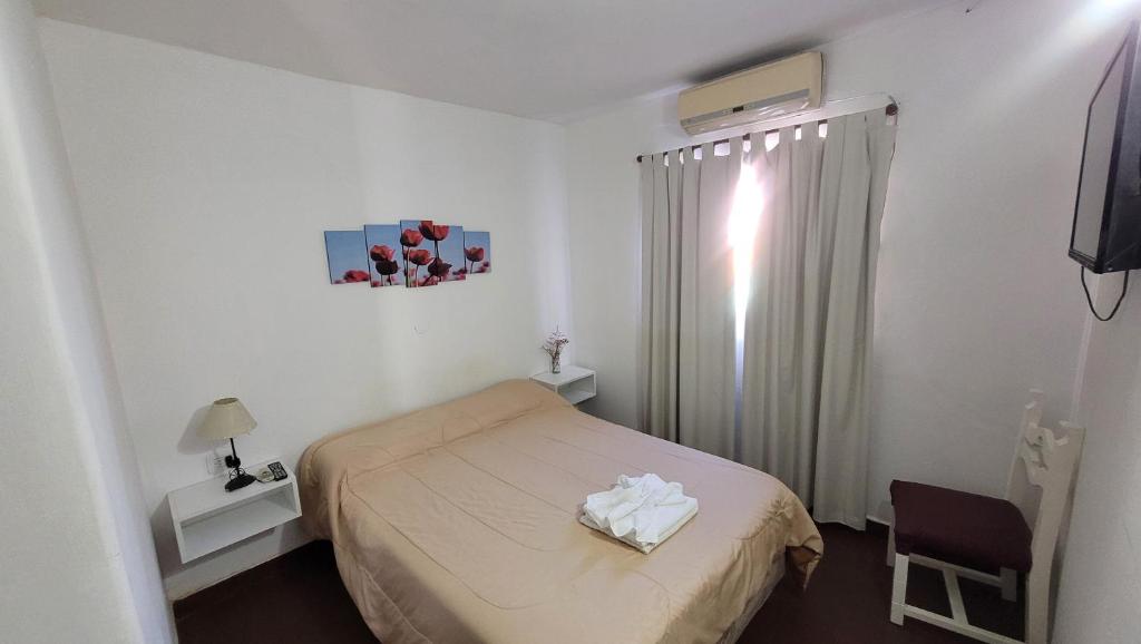 Un dormitorio pequeño con una cama y una ventana. en Hotel Belgrano, en Villa Carlos Paz