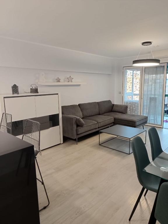 a living room with a couch and a table and chairs at Alice Home in Puebla de Farnals