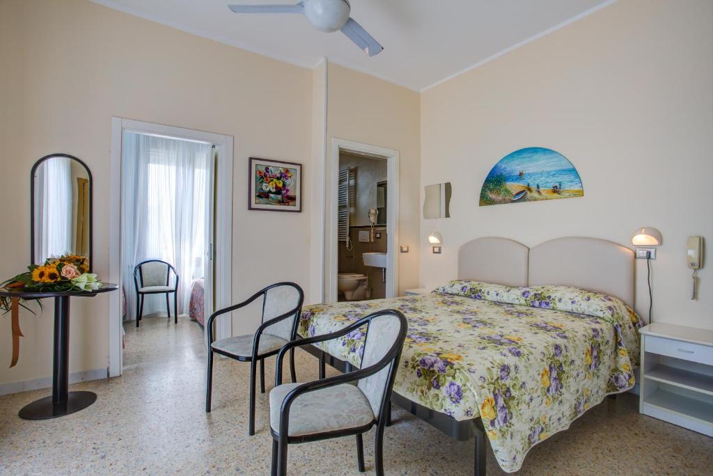 um quarto com uma cama, uma mesa e cadeiras em Hotel Deanna em Bellaria-Igea Marina