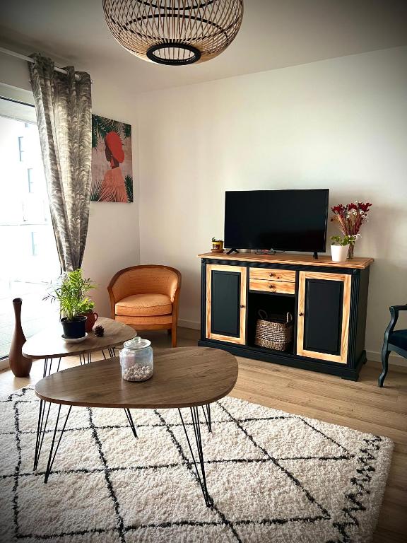 un salon avec une télévision et une table basse dans l'établissement Appartement Vannes Odyssée, à Vannes