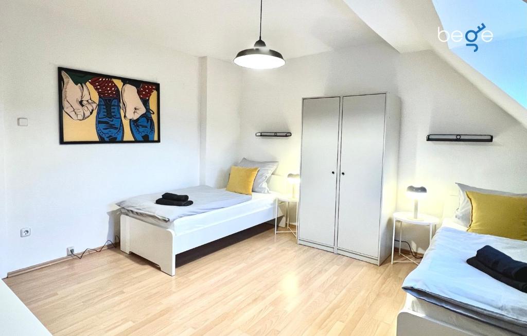 a bedroom with two beds and a closet at BEGE APARTMENTS WorkLodge in Duisburg
