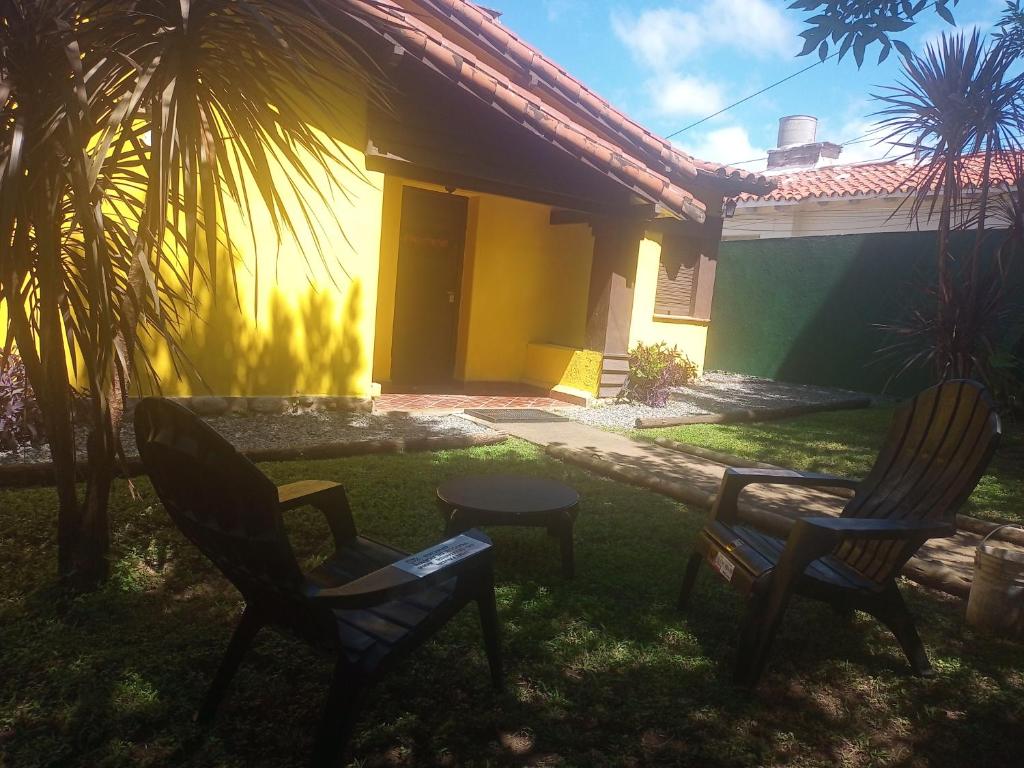 dos sillas y una mesa frente a una casa en Paloma Chalets, en La Falda